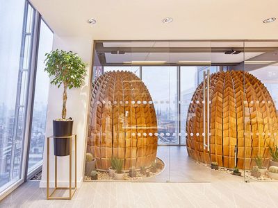 Two wooden pods in a glass-walled room