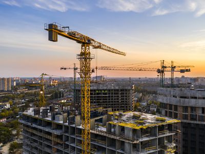 Crane looming over construction site at sunset