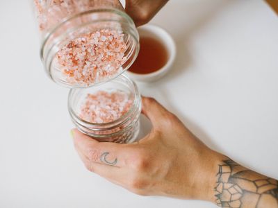 tattooed hand pours diy salt scrub