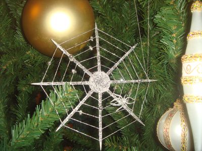 silver spider christmas ornament nestled in green Ukrainian tree