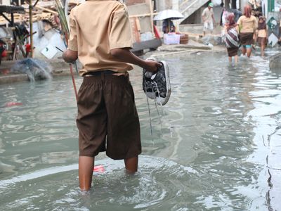 Child wading in knee-deep water during flood