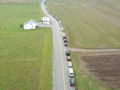 Cars in line on rural highway waiting to purchase milk from dairy