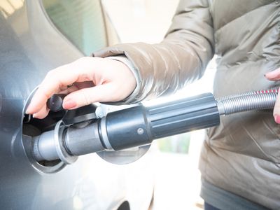 A woman pours fuel (CNG gas) into the car. Germany