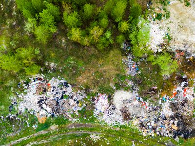 Aerial view of dump or landfill in forest. Pollution concept, top view.