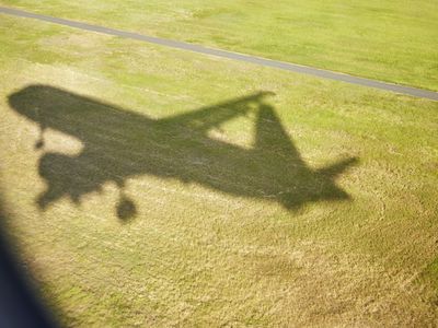 Air travel, airplane shadow landing, passenger view, airport runway grass area