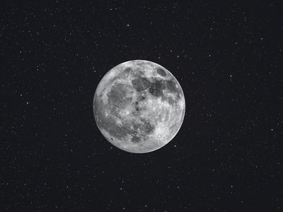 photo of moon at night, surrounded by stars