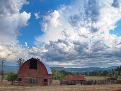 small homestead with classic red barn and brilliant blue sky with clouds