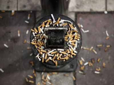 Cigarette butts overflowing outdoor ashtray