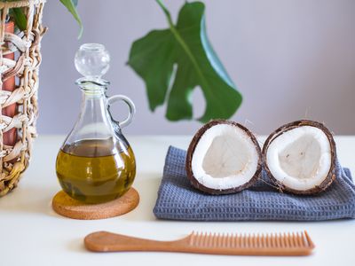 olive oil, split fresh coconut, comb, and towel for diy hair mask