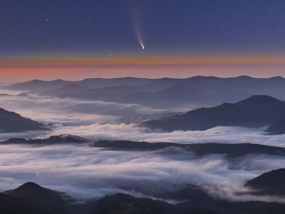 Comet Neowise C/2020 F3 at sunset over misty mountains