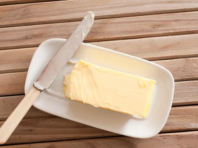 Directly Above Shot Of Butter And Knife On Wooden Table