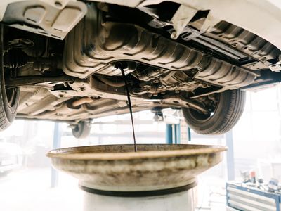 Engine oil drain unit. Car on a lift in a car service.