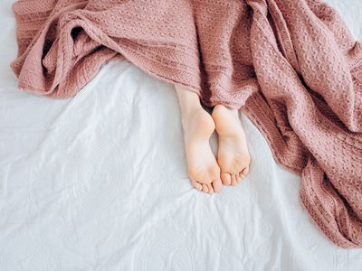 Feet of woman lying in bed