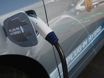 a hybrid vehicle is plugged into gas pump