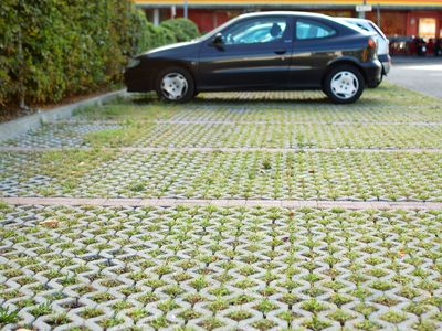 A permeable parking lot with grass growing between pavers.