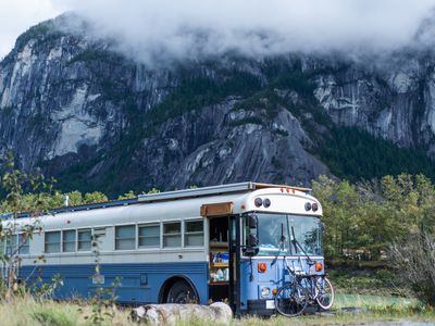 Bus with bikes on front rack parked near a mountain