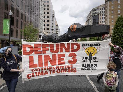 Environmental activists carry a large snake pipeline as they protest against the Enbridge Line 3 oil pipeline on May 7, 2021 in Washington, DC. 