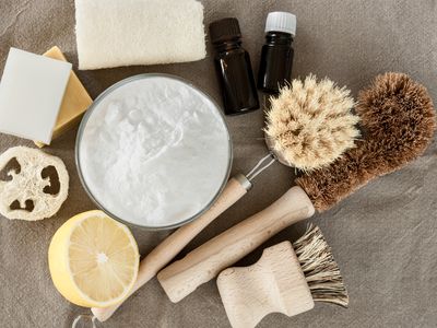 glass bowl of baking soda and eco friendly brushes and cleaning products for kitchen