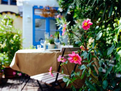 View on terrace with flowers and a covered table for lunch