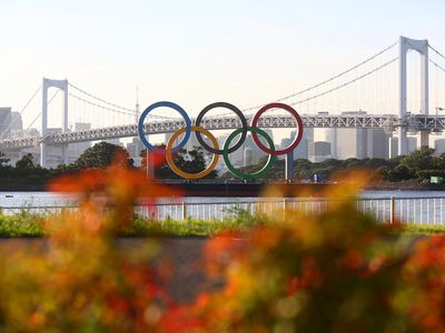 A general view of the Olympic rings installation and Rainbow Bridge as the sun sets on day twelve of the Tokyo 2020 Olympic Games at Odaiba Marine Park on August 04, 2021 in Tokyo, Japan.