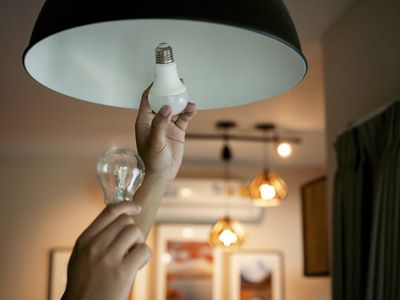 Person replacing a conventional light bulb with an energy efficient one.