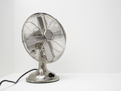 Silver fan displayed on a white table