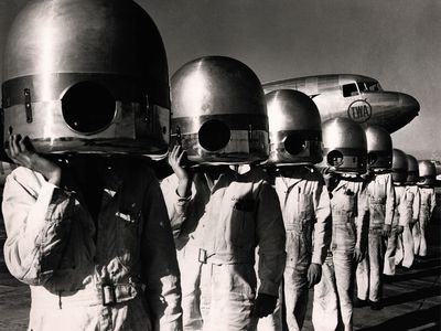 1941 photo showing plane mechanics and the future of plane travel with TWA plane