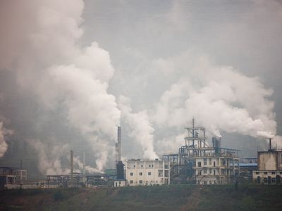 Cement factories with white plumes gas coming out of stacks