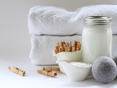 sustainable laundry detergents in glass containers with towels and clothespins