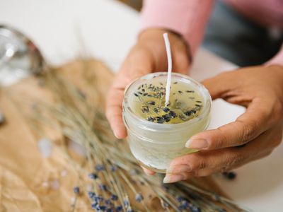 hands hold diy soy candle with lavender