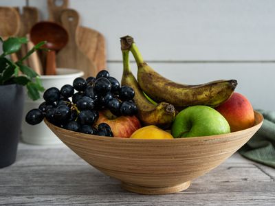 bowl of old fruit and bruised banana that attract fruit flies on kitchen counter