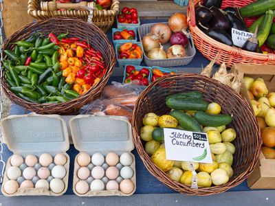 bright vegetables for sell at outdoor farmer market including cucumbers and eggs