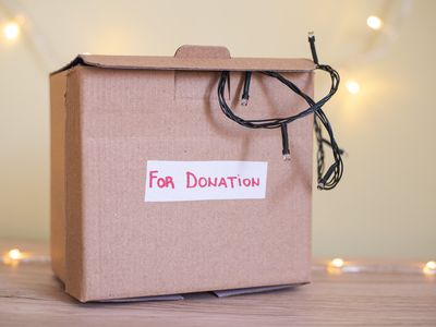 cardboard box full of christmas junk and lights marked for donation