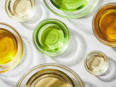 various kinds of oils (castor, olive, almond, coconut) in glass bowls with light reflecting