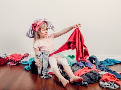 Little girl in a pile of clothes