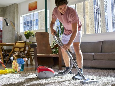 man vacuuming a rug