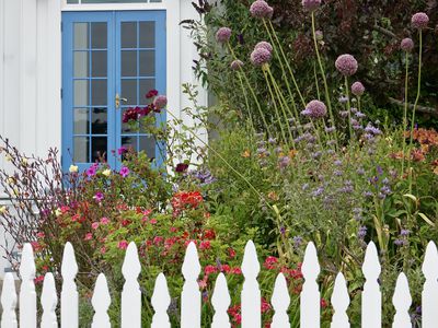 Quaint cottage garden with vintage white picket fence