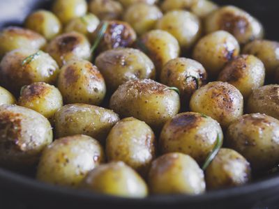 Roasted young potatoes with herbs, thyme, salt with oil or butter. Fried little round baby potatoes, close up view