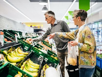 senior couple shops for produce at grocery store