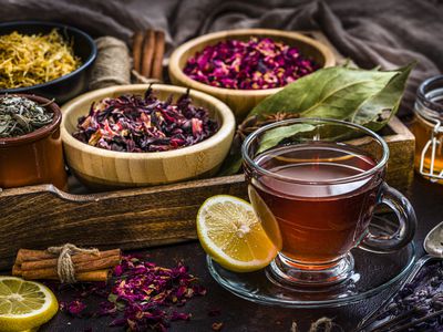 Tea cup with several dried tea leaves and flowers