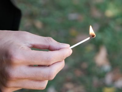 hero shot lit match with hand