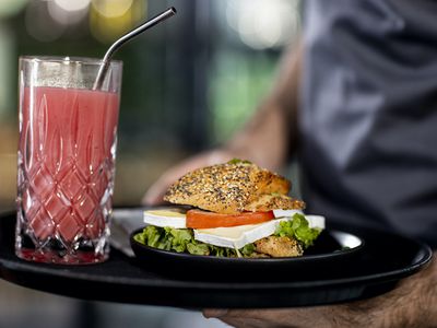 waiter carries tray with food in reusable dishes