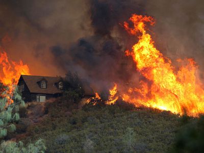 Flames from the Rocky Fire approach a house on July 31, 2015 in Lower Lake, California. 