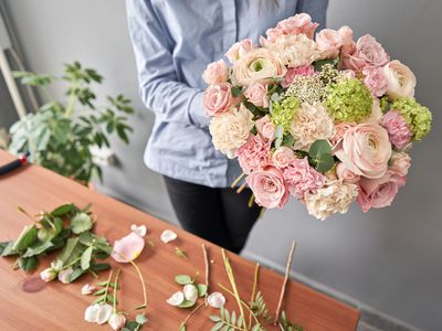 Woman florist creating beautiful bouquet in flower shop. Work in flower shop. Flowers delivery.