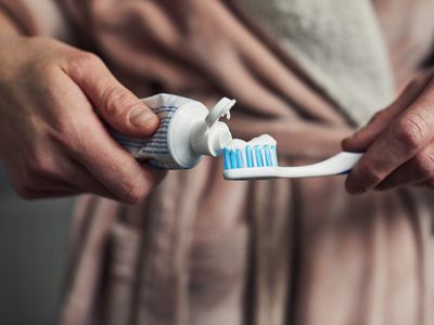 Woman putting toothpaste on a toothbrush