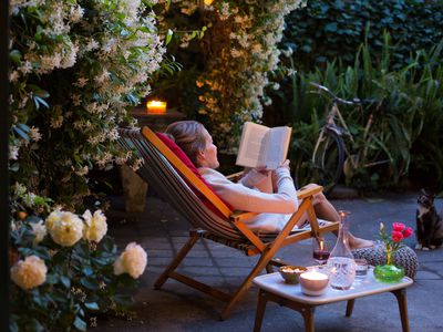 woman reading in a cozy garden