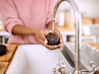 woman washes avocado in sink