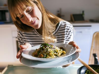 woman with bowl of vegan pasta