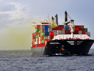 Cargo ship at sea with brownish fumes coming from a container amidships